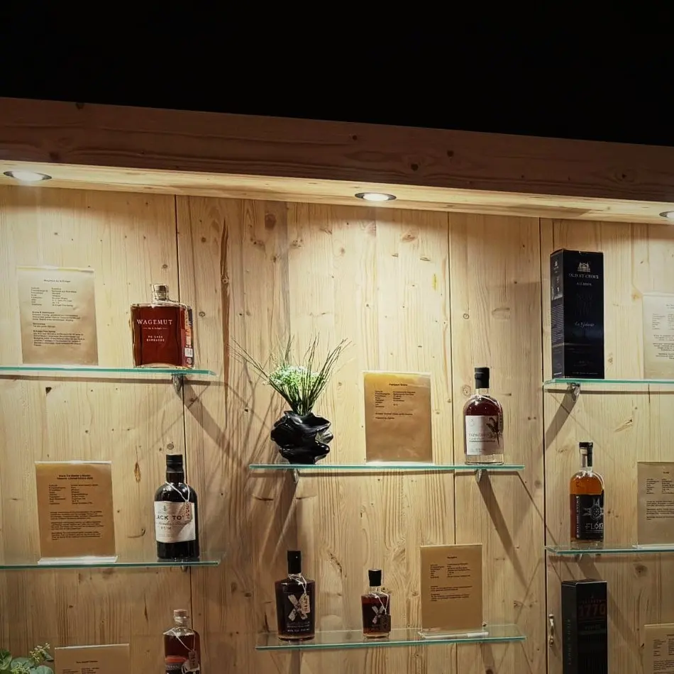 Whisky-Flaschen auf Glasböden vor hellem Holz